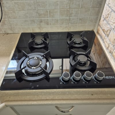 כיריים גז שחורות עם חמישה מבערים וכפתורי שליטה