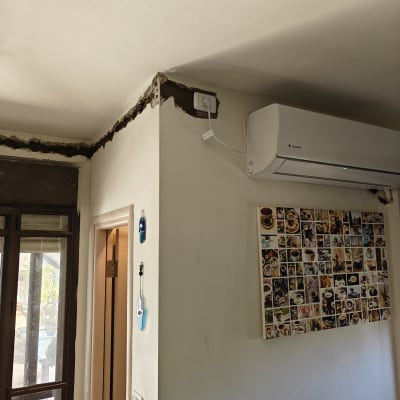 שקע חשמל עם כבל ליד מזגן על קיר