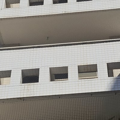 רשת הגנה מותקנת על מרפסת בניין למניעת כניסת יונים