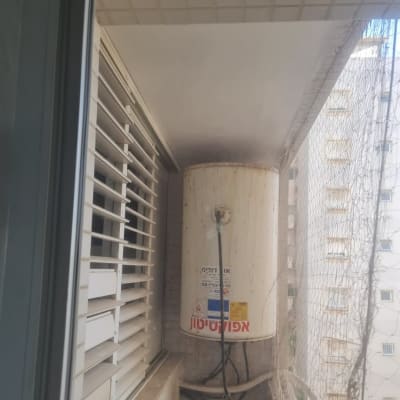 דוד שמש ישן עם סימני חלודה על מרפסת