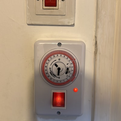שעון טיימר ומתג חשמלי על קיר