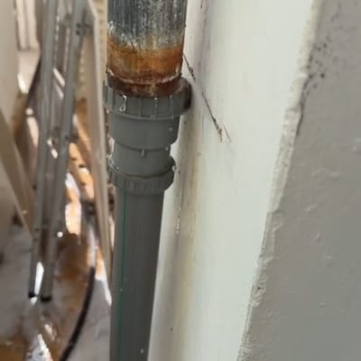 צינור חלוד עם נזילה על קיר חיצוני