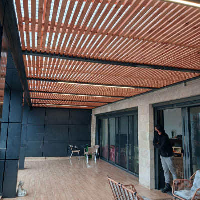 פרגולה מעץ עם ריצוף עץ וכיסאות גן