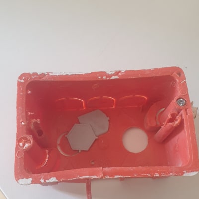 תיבת חיבורים חשמלית כתומה עם חורים וברגים