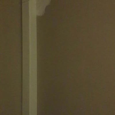 צינור לבן על קיר חום, תיקון צבע בקיר