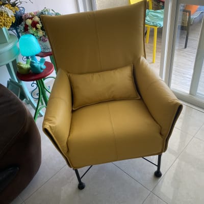 כורסה צהובה עם כרית תואמת על רצפת אריחים