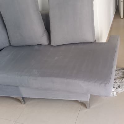 ספה אפורה עם כריות על רצפת אריחים