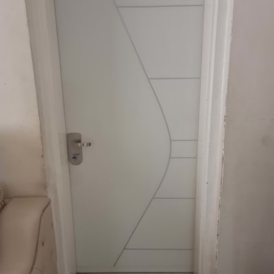 דלת לבנה עם ידית מתכת ועיצוב גיאומטרי