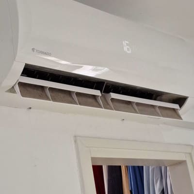 מזגן קיר לבן עם תצוגת טמפרטורה דיגיטלית