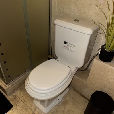 אסלה לבנה בחדר אמבטיה עם קיר אבן