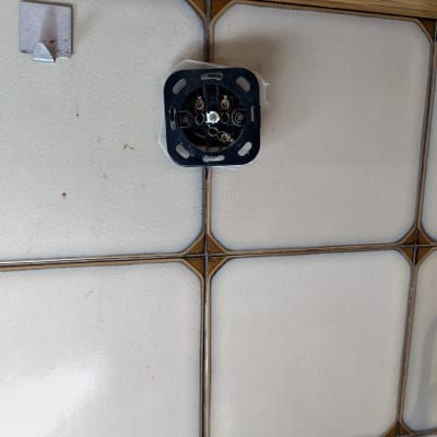 שקע חשמלי פתוח על קיר אריחים