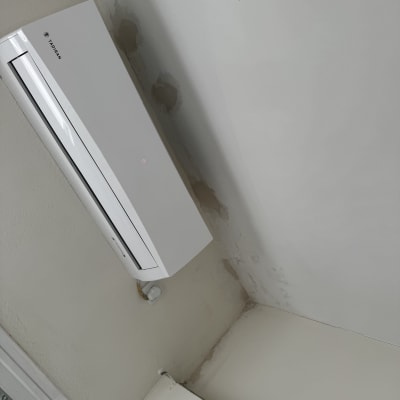 מזגן מותקן על קיר עם סימני רטיבות