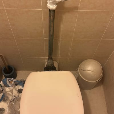 אסלה עם צינור מים עטוף בסרט לבן