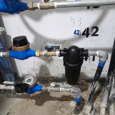 צנרת מים עם מדי מים ושסתומים כחולים