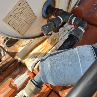 צנרת וחיבורים על דוד שמש עם חלודה