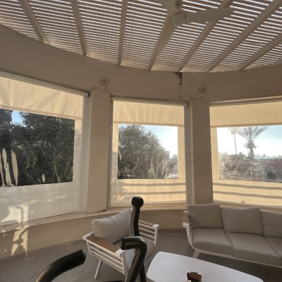 מרפסת עם סוככים לבנים חצי שקופים על חלונות