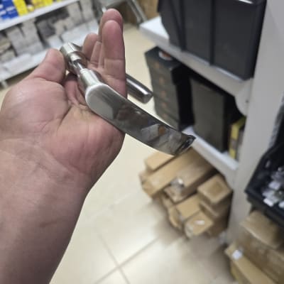 ידית דלת מתכתית מוחזקת ביד בחנות כלי עבודה