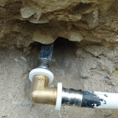 צינור מתכת עם מחבר זוויתי בקיר אבן