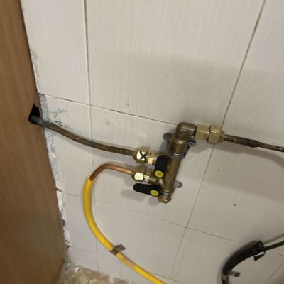 צינור גז צהוב עם ברזים ומחברים על קיר