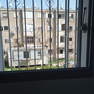 סורגים עם עיטורים על חלון מול בניין מגורים