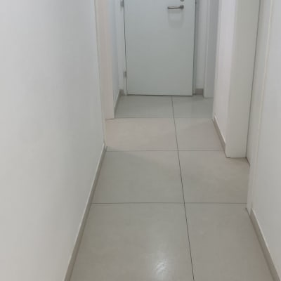 מסדרון נקי עם רצפה מבריקה ודלת לבנה