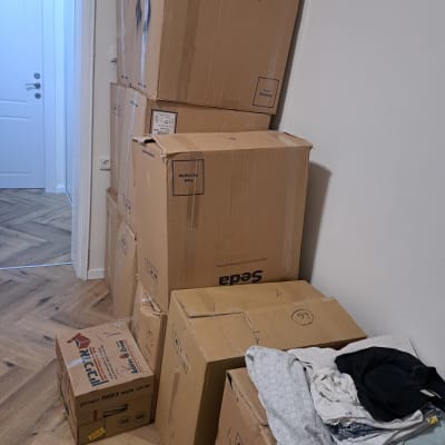 קופסאות קרטון עם בגדים מונחים על הרצפה