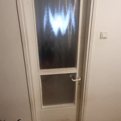 דלת לבנה עם זכוכית מטושטשת וידית לבנה