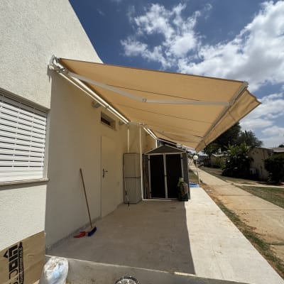סוכך מותקן על קיר חיצוני עם שמיים בהירים