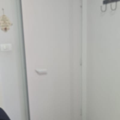 דלת לבנה עם ידית פשוטה על רקע קיר לבן