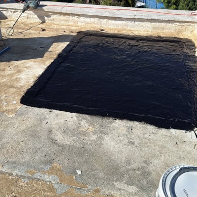 איטום גג עם חומר שחור וכלי עבודה