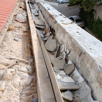 גג עם רעפים שבורים ופסולת בנייה