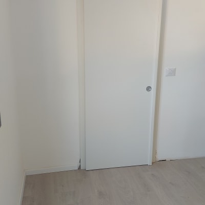 דלת הזזה לבנה על קיר לבן