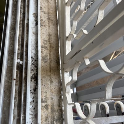 חלון מלוכלך עם סורגים ולכלוך על המסגרת