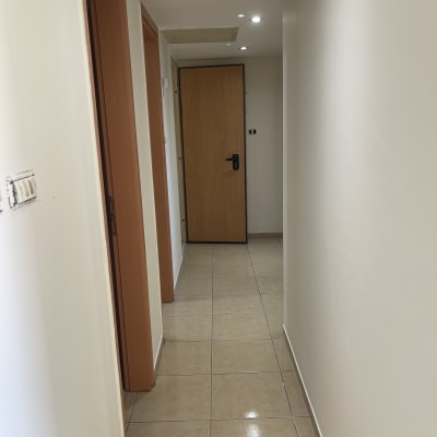 מסדרון עם קירות צבועים בלבן ודלתות עץ