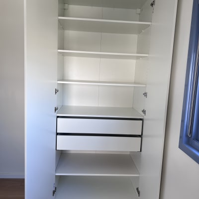 ארון לבן עם מדפים ודלתות פתוחות