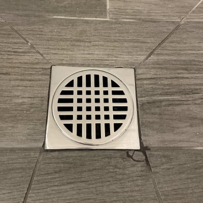 רצפת אריחים עם פתח ניקוז עגול