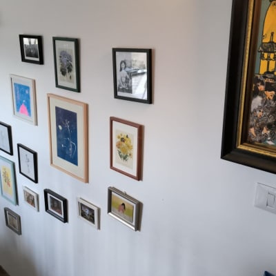 קיר עם תמונות ממוסגרות ומדפים עם ספרים