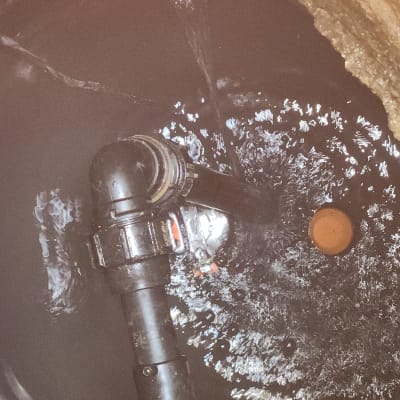 צינור פלסטיק שחור עם חיבורי מתכת במים