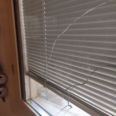 חלון זכוכית שבור עם תריסים סגורים