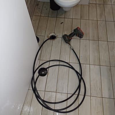 כבל אינסטלציה וכלי עבודה על רצפת חדר אמבטיה