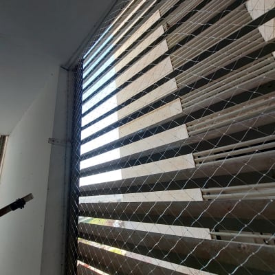 רשת מתכת מותקנת על חלון למניעת כניסת יונים