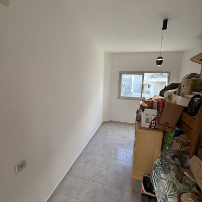 חדר צבוע עם קיר לבן ורצפת אריחים אפורה