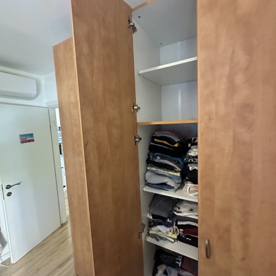 ארון עץ פתוח עם בגדים מקופלים על מדפים