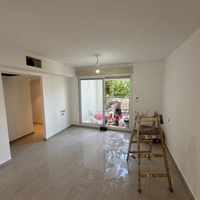 סולם עץ, דלי צבע, קירות צבועים בלבן