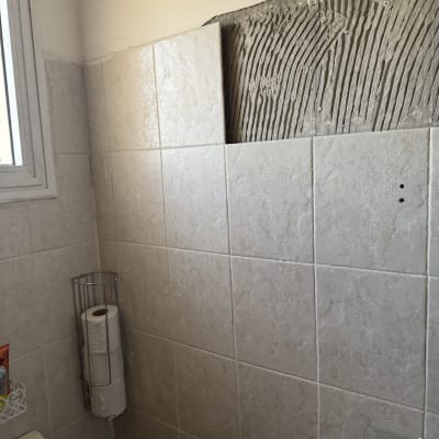 קיר עם אריחים חסרים ותשתית דבק חשופה