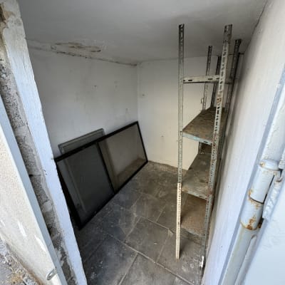 מדף מתכת חלוד בחדר קטן עם רצפת אריחים