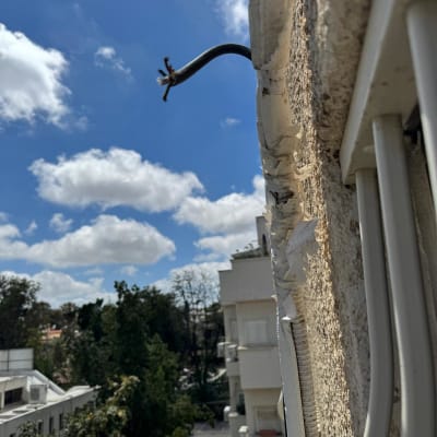 כבל חשמל חשוף על קיר חיצוני של בניין