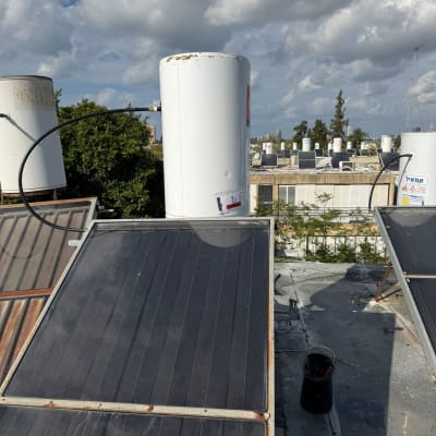 דוד שמש וקולטים על גג תחת שמיים מעוננים