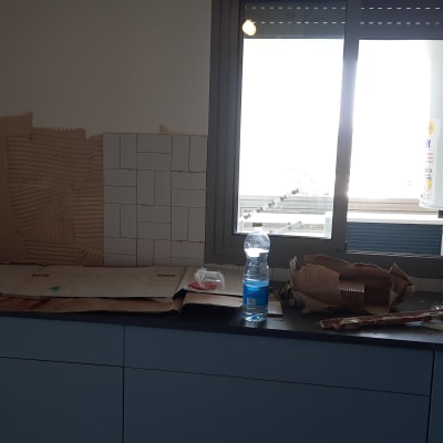 מטבח בשיפוץ עם אריחים וכלי עבודה על השיש