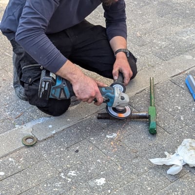 אדם משתמש בכלי עבודה על המדרכה